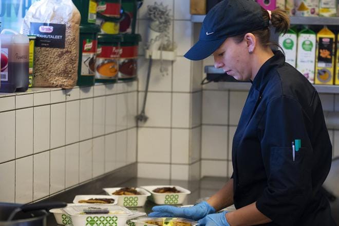 Café Uimalan ravintolapäällikkö Outi Peltoniemi pakkaa lounaalta ylijäänyttä ruokaa. Sitä tapahtuu lähes joka päivä, mutta annosmäärä vaihtelee yhdestä jopa kolmeenkymmeneen. KUVA: JARNO PELLINEN