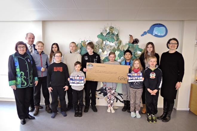 Hietalahden koulun vuosikalenterin tehneet taiteilijat Onni, Camilla, Phongphisut, Aleksi, Daniel, Veeti, Seela, Sofia, Tino, Emilia ja yrittäjyyskasvatusvastaava opettaja Sari Havusela luovuttivat shekin Raimo Latvalalle ja Tuula Harjunpäälle. Kuvasta puuttuu lahjakortin tekijä Aleksi Haapamäki. KUVA: ULLA MARTONEN