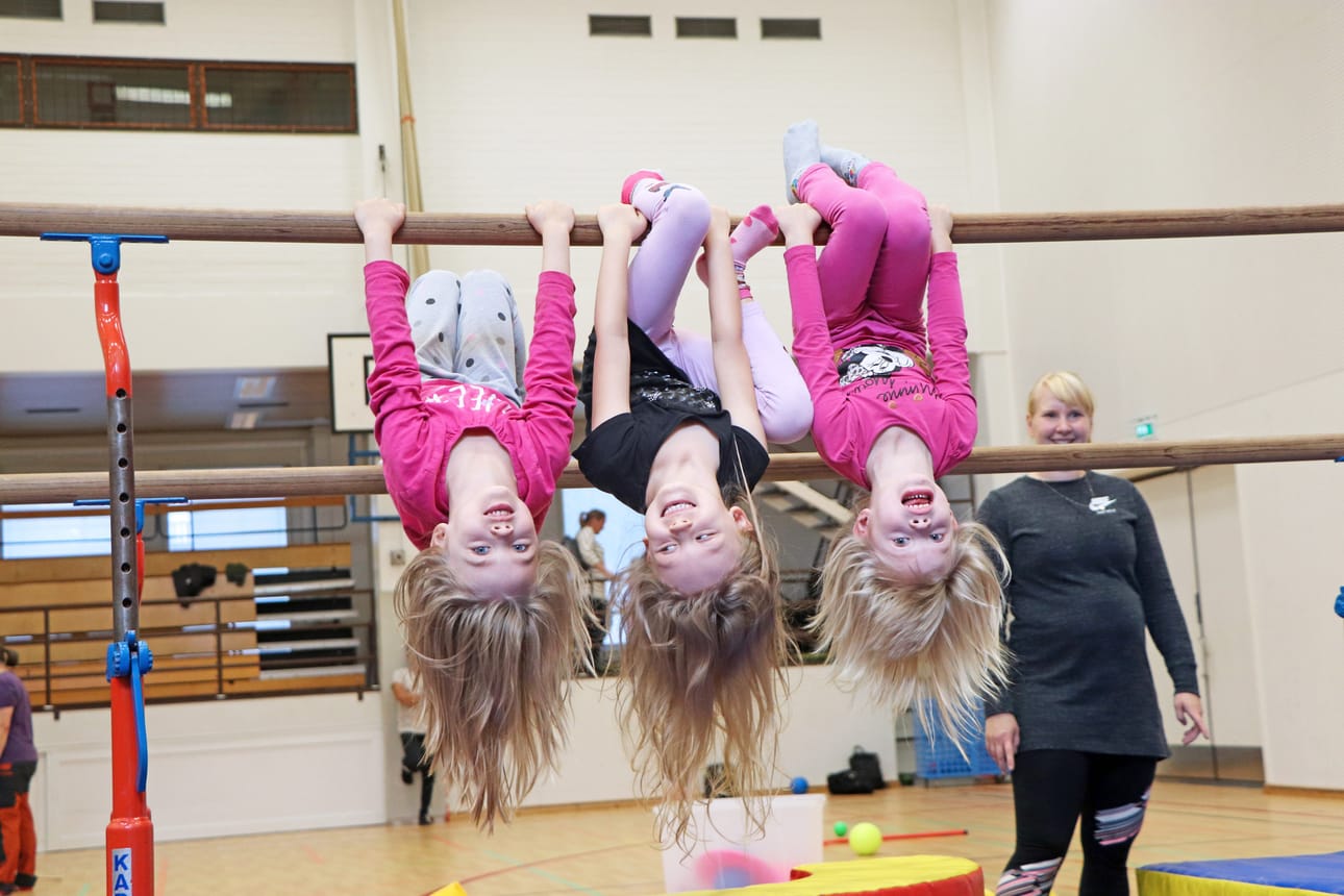 Maija Nyström, Maisa Tikkanen ja Enni Nyström nauttivat rimpuilemisesta. Liikunnanohjaaja Elina Wachira auttaa pieniä temppuilijoita tarvittaessa.