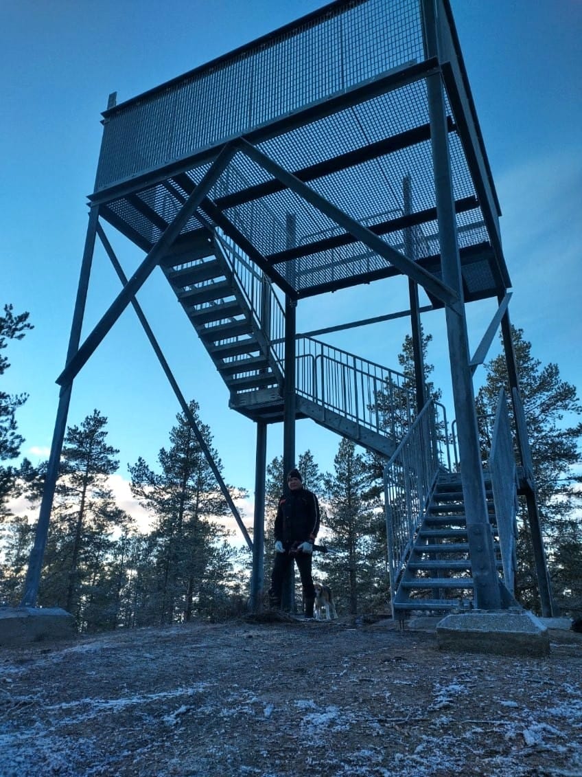 Kakkorinvuoren uudessa näkötornissa päädyttiin teräkseen rakennusmateriaalina, koska se on puuta helppohoitoisempi. Tornin alla Juha Myllyniemi. Hänen takanaan luuraa Matti Hietasen Romu-koira.