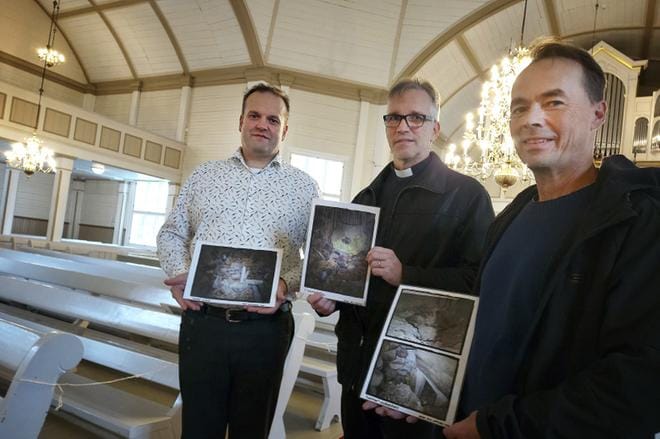 Antti-Kalle Levijoella, Ari Aurasella ja Juha Tuomelalla on käsissään laminoitua valokuvamateriaalia Alajärven kirkon lattian alla yhä olevasta vanhemman kirkon kellarista. KUVA: SARI HEINILÄ