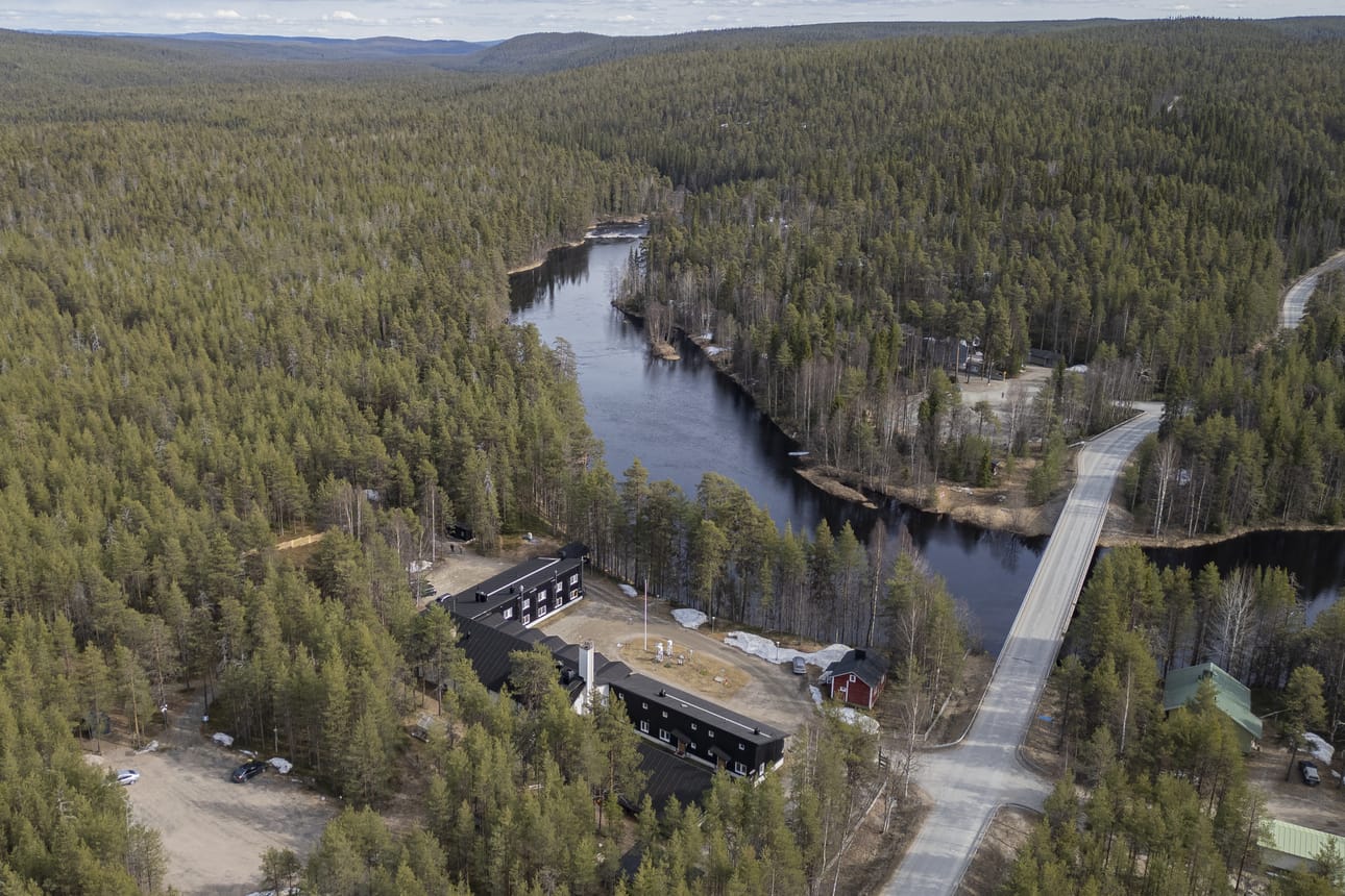 Oulankajokilaakso Oulangan kansallispuistossa. Kuvassa etualalla Oulangan tutkimusasema, Metsähallituksen kiinteistöjä (vihreät rakennukset) sekä joen vastarannalla Oulangan luontokeskus. Vedenkorkeuden mittauspaikka on joen tässä kohtaa.