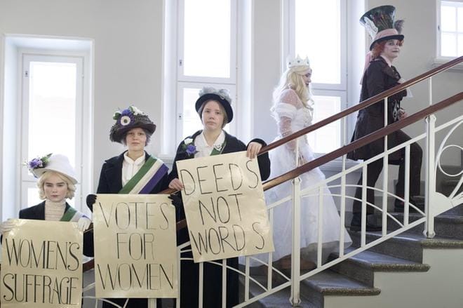 Suffragetit Tuulia Häkkinen, Ella Nybäck ja Anna Koskela olivat ommelleet ja kuumaliimailleet asunsa itse kansaan. Osa vaatteista löytyi kirpputorilta, osa mummolta tai äidiltä. Taustalla Valkoinen kuningatar Nella Valkama ja Hatuntekijä Milja Pukkila. KUVAT: MINNA ANTILA