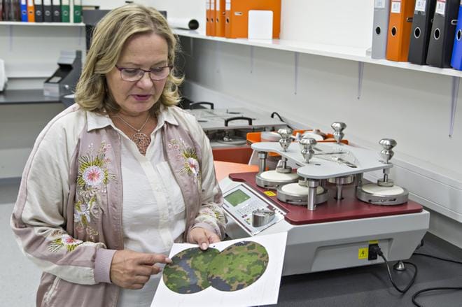 Foxan tuotepäällikkö Marjaana Naatula esittelee kangasnäytettä, joka on käynyt kulutustestin läpi. Jos kangas kuluu testissä valkoiseksi, ei se kestä riittävästi kulutusta työ- ja ulkovaatteissa. Kuva: Tapio Tuomela