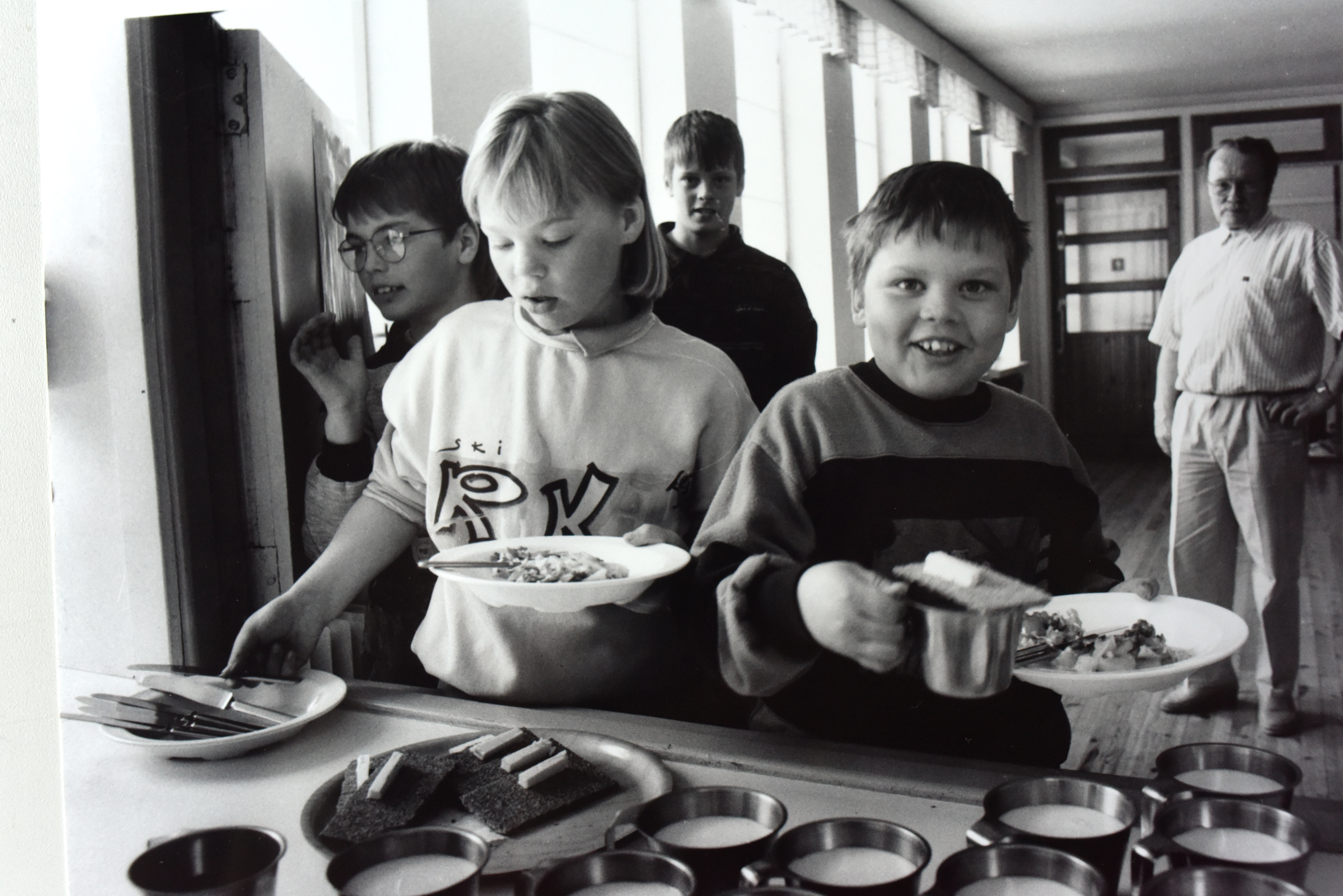 Kouluruokailukuva Heikkilän koululta 1990-luvun alusta. Taustalla opettaja Haaranen. Edessä Harri Määttä, Kaisa Heiskanen, Risto Heikkilä ja Henri Hentilä.