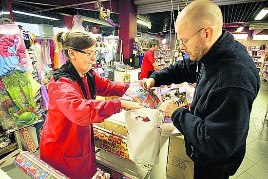 Pukin apurit. Lelu-Tapulin myymälänhoitaja Kerttu Hietala pakkaa Riku Pennalan tuttavien ja sukulaisten lapsille tarkoitettuja lahjapaketteja.