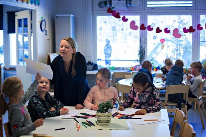 Aurora Palomäki näyttää piirustustaan Teija Vähälummukalle. Saman pöydän äärellä taiteilevat myös Laila Hautala, Petra Perälä ja Mia Suopelto. KUVAT: MINNA ANTILA