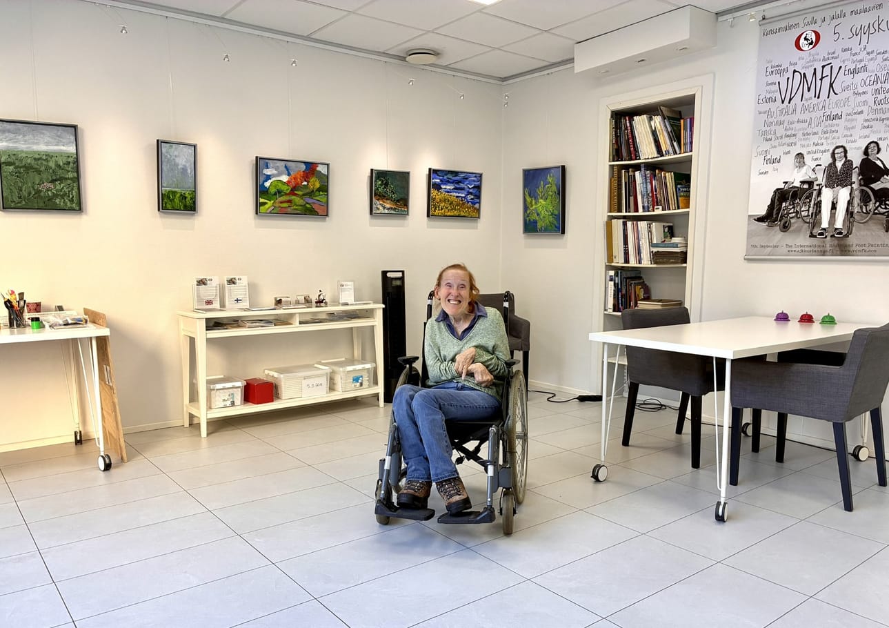 Lissu Lundström maalaa värikkäitä taulujaan valoisassa galleriassaan Helsingissä.