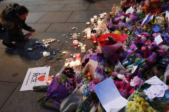 Manchesterissa nainen muisti maanantaisen terrori-iskun uhreja. Britanniassa viranomaiset ovat asettaneet terroriuhka-arvionsa korkeimmalle mahdolliselle tasolle. Kuva: Andy Rain/EPA