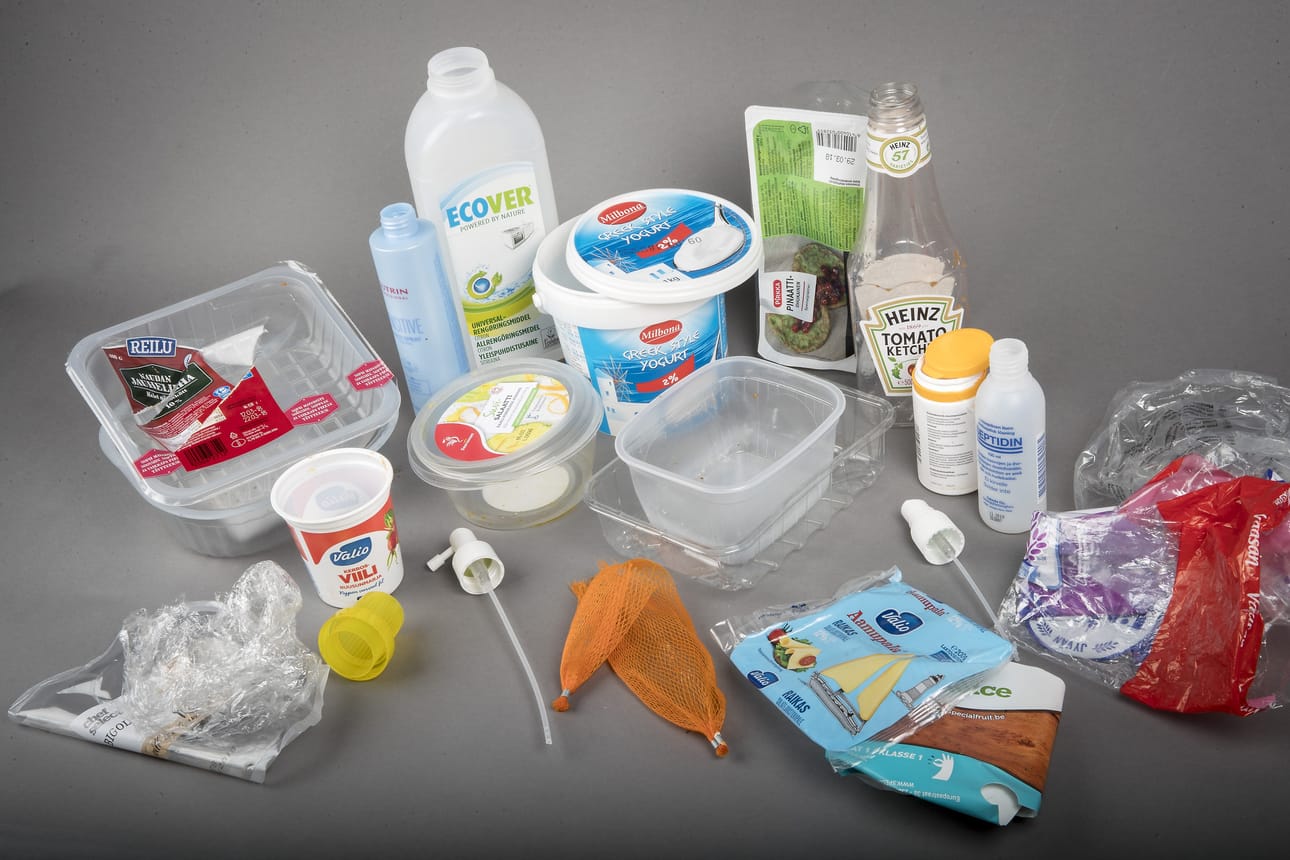 Tässä kuvassa on nelihenkisen perheen sattumanvaraisena päivänä tuottama muovijäte. Korkit, kannet ja pullojen pumppuosat tulee irrottaa pakkauksista, sillä ne ovat usein eri muovilaatuja. Jos niitä ei erotella, osa muovista päätyy koneellisen lajittelun päätteeksi väärään ryhmään.