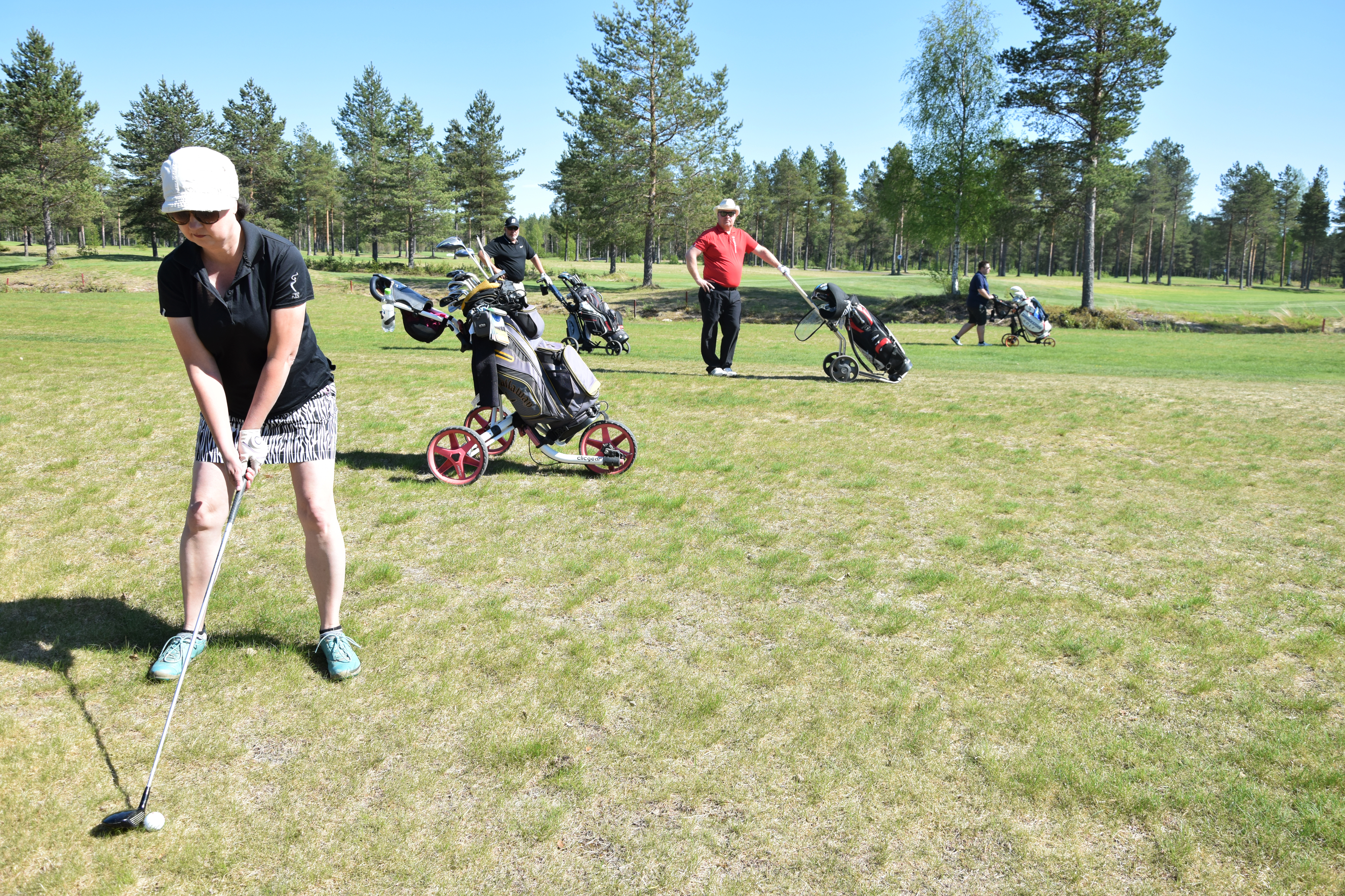 Merja Hammar 11. väylällä. Meneekö lipulle vaiko ei? Taustalla tarkkailemassa Janne Ypyä ja Risto Maliniemi.