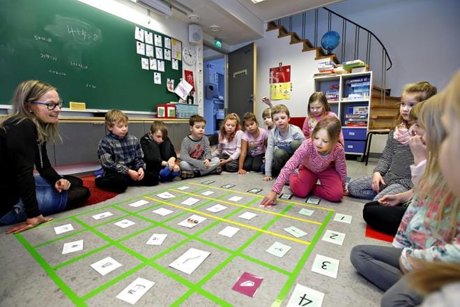 Lastentarhanopettaja Anne Mäki pitämässä oppintuntia ekaluokkalaisille ja esikoululaisille. On ekaluokkalaisen Pinja Vainion vuoro kokeilla opetuspeliä. KUVA: TOMI KOSONEN