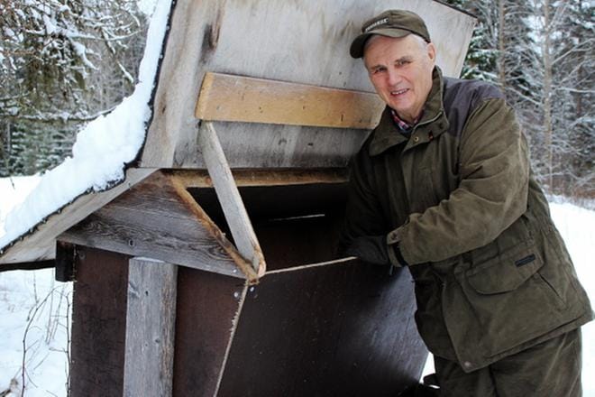 Jukka Lahtinen tarkasti riistanruokintapaikkaa. Lumessa olevista jäljistä näkyi, että kauriit ja valkohäntäpeurat olivat käyneet syömässä. Lahtinen metsästää ja kalastaa mieluusti. KUVA: TARJA RIIHIMÄKI