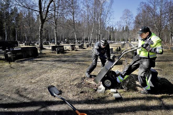 Vesa Kangas (oik.) ja Pekka Kohtakangas nostivat kaatuneen hautakiven väliaikaisesti lankkujen päälle tiistaina Törnävän hautausmaalla Seinäjoella. KUVA: HEIKKI HAKANEN