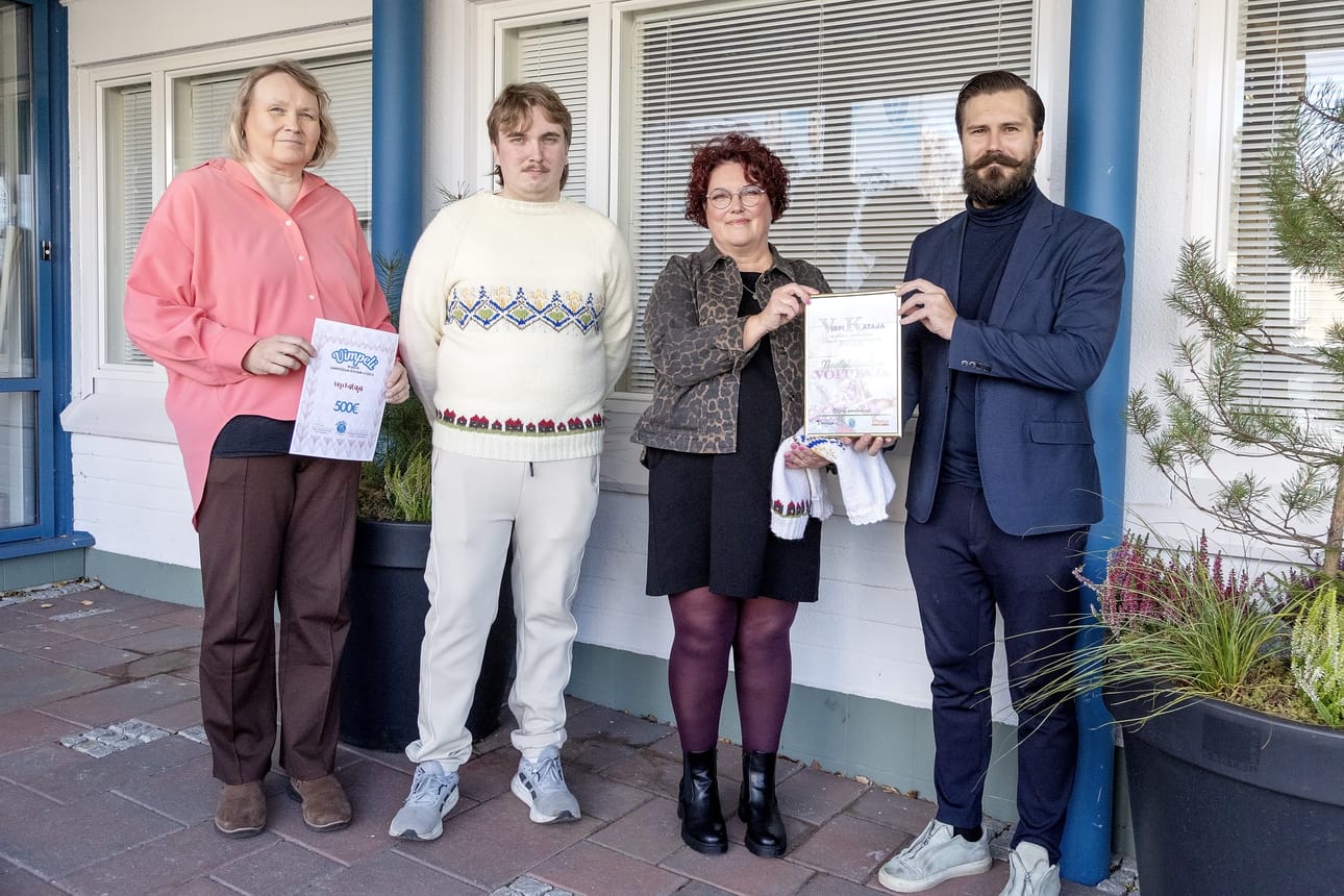 Virpi Kataja vastaanotti neulesuunnittelukilpailun voitostaan kunniakirjan, jota oli luovuttamassa kunnanjohtaja Sam Leijonanmieli. Palkinnoksi hän sai myös 500 euroa, josta todisteen ojensi hallinto- ja talousjohtaja Eveliina Nokua-Keisanen. Ensimmäisen Vimpeli-paidan sai ylleen Katajan nuorin poika Konsta Kataja.