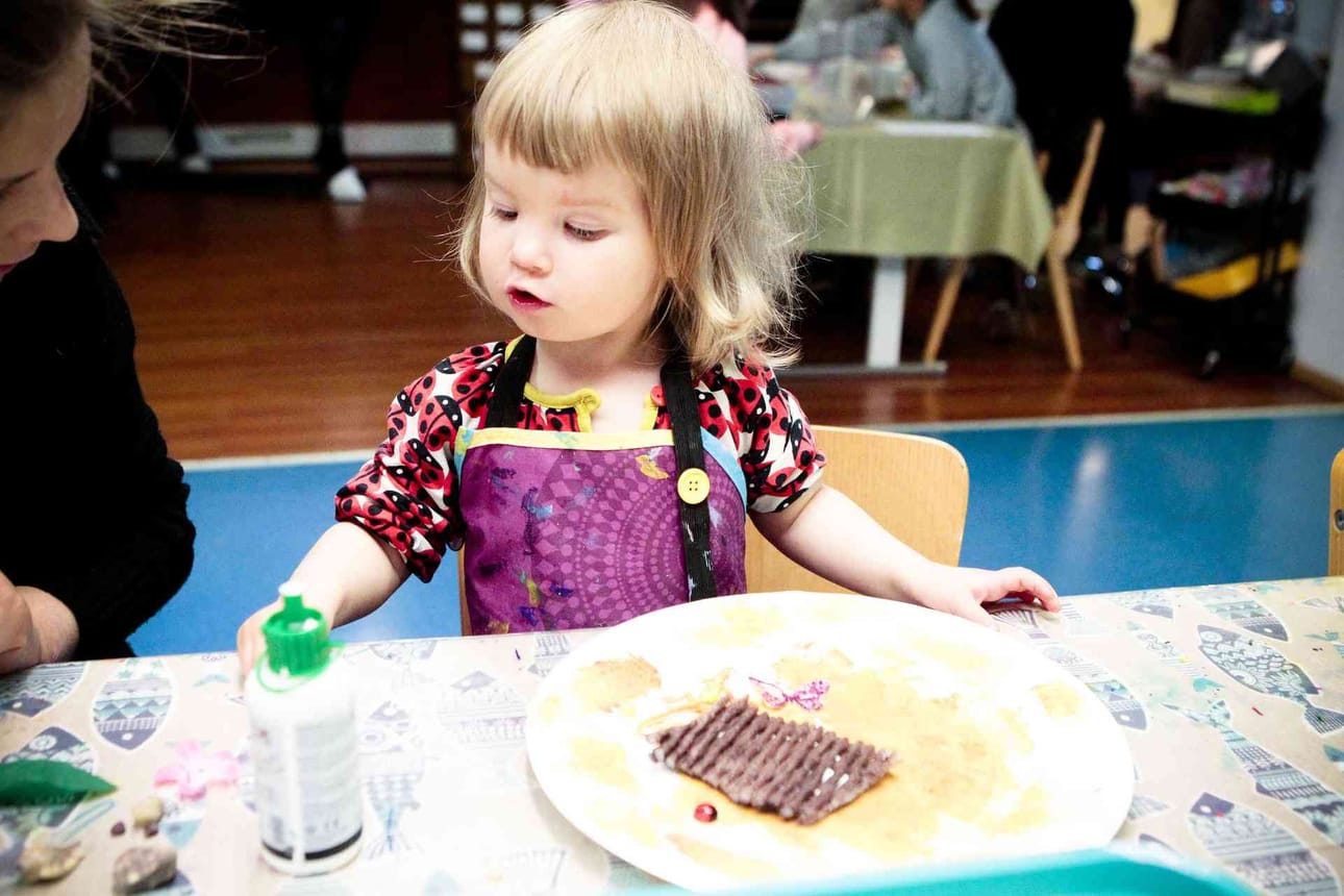 Ella Heikkinen askartelee äidin avustuksella.