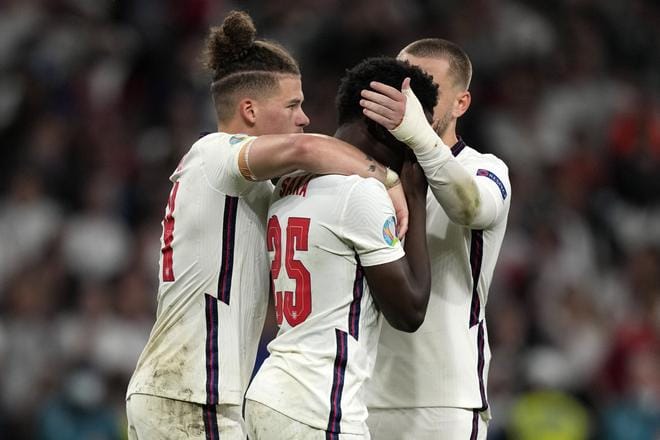 Bukayo Saka (keskellä) epäonnistui ratkaisevassa rankkarissa ja Englanti hävisi EM-finaalin. Joukkuetoverit lohduttivat lohdutonta pelaajaa, jonka kimppuun osa niin sanotuista kannattajista hyökkäsi sitten vielä rasistisin iskuin sosiaalisessa mediassa.