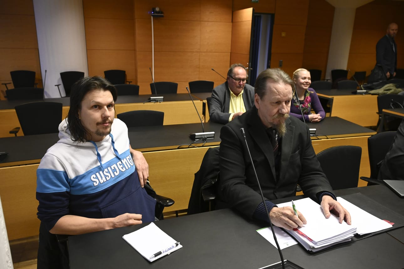 Syytetty Marko Vapa (vas.) ja niinikään syytteen saanut Anne Vapa (takana oikealla) istuntosalissa Helsingin käräjäoikeudessa tiistaina. Anne Vapa on kolmannen syytetyn Mikko Vapan puoliso. Mikko Vapa ei saapunut istuntoon.