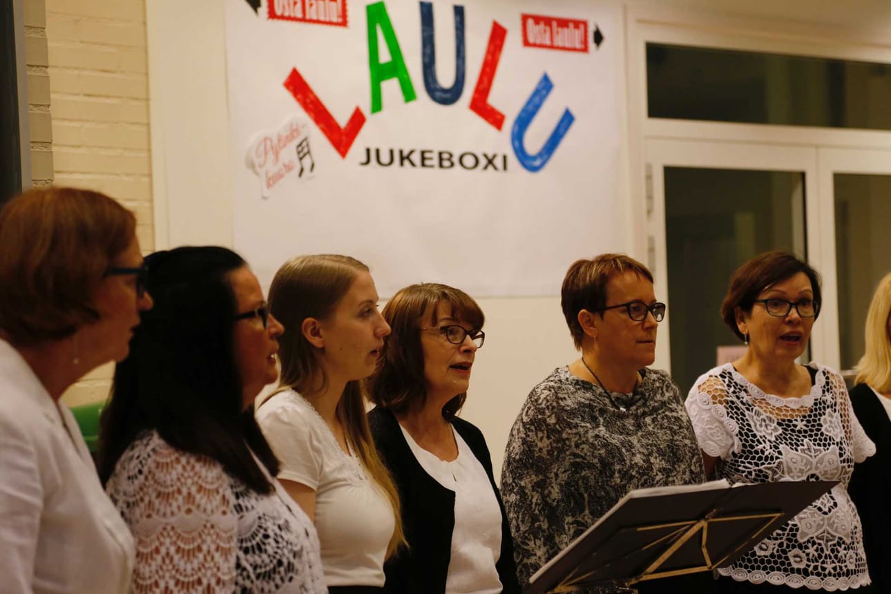 Pytinki-kuoron laulu-jukeboksi soi Kauppaporvarin aulassa.