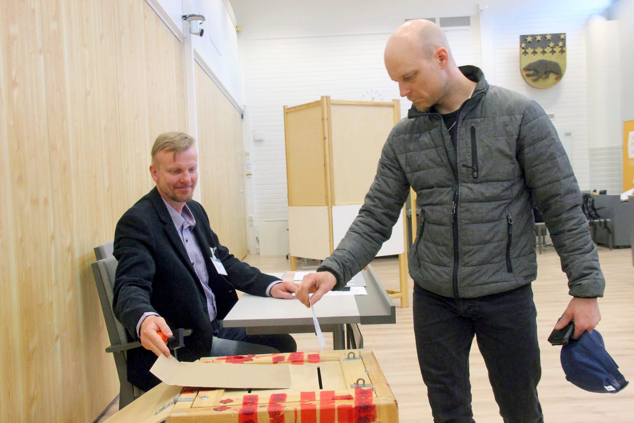 Mika Niskasaari valvoo kun Markus Luokkanen tiputtaa eduskuntavaalien äänestyslipukkeen vaaliuurnaan. Kaupungintalon äänestyspaikalla oli sunnuntaina iloinen tunnelma ja äänestäjiä kävi tasaiseen tahtiin.