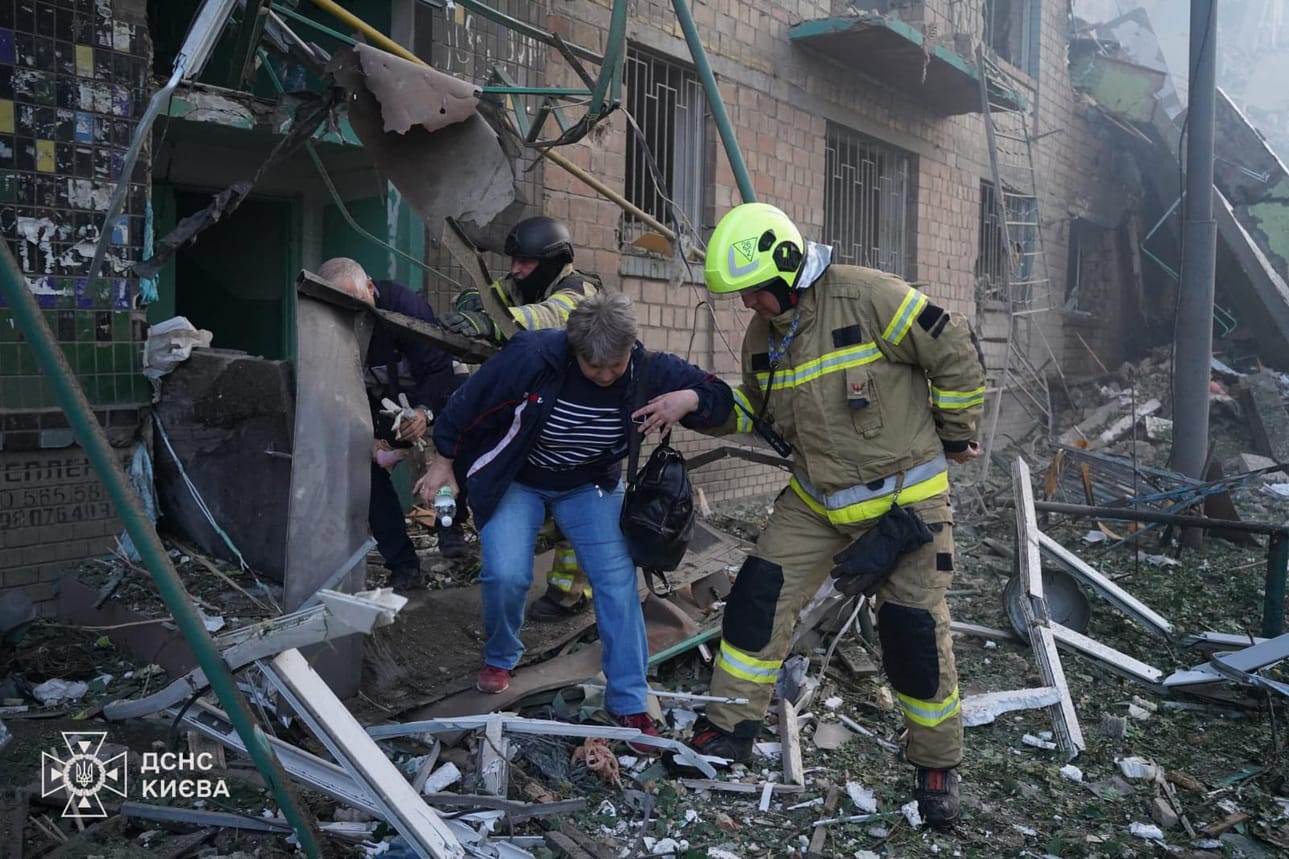 Ukrainan pelastusviranomaisten maanantaina julkaisemassa kuvassa asukkaita evakuoidaan Venäjän iskujen vaurioittamasta asuintalosta Kiovassa. LEHTIKUVA/AFP/HANDOUT/Ukrainian State Emergency Service.