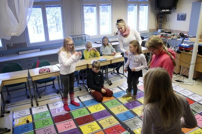 Ella Hietala (vas.), Juuso Finnilä, Elli-Maija Hietala, Niina Raja-aho ja Milena Haapa-aho opiskelevat matematiikkaa toiminnallisuuten kannustavan maton avulla, joka on Sari Salon suunnittelema. Tilannetta seuraavat Leevi Lepistö ja Keira Finnilä. KUVA: JOHANNA KATAJA