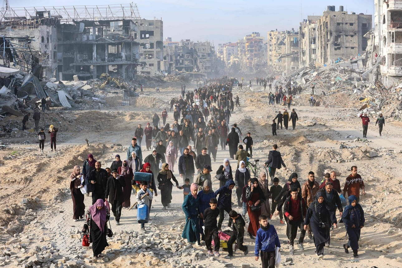 Joukko palestiinalaisia matkasi sunnuntaina Gazan kaupungin lähettyviltä kohti alueen pohjoisosia, kun aselepo oli astumassa voimaan. LEHTIKUVA/AFP