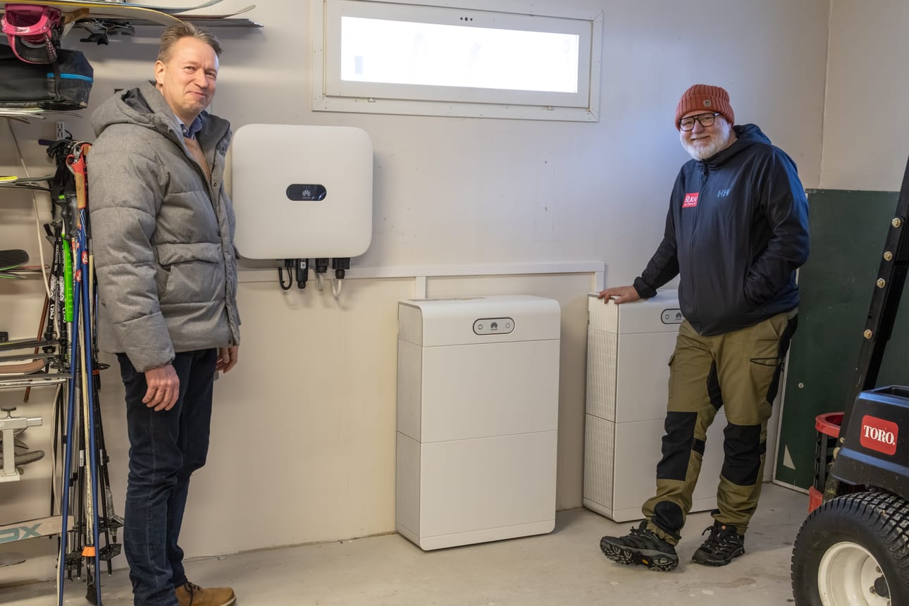 Sami Raittinen (oik.) ja aluejohtaja Markus Ahokangas Raittisten uuden hankinnan äärellä. Kaksi Huawein valmistamaa akkua sijoitettiin lämpimään autotalli-varastoon.