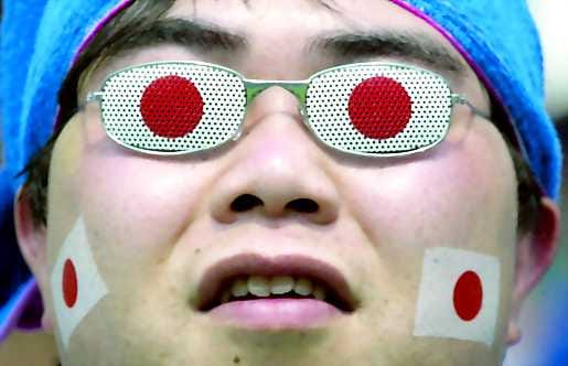 Punavalkoiset lasit. Japanin väreihin sonnustautunut kannattaja on - todennäköisesti - kohtelias mies.
