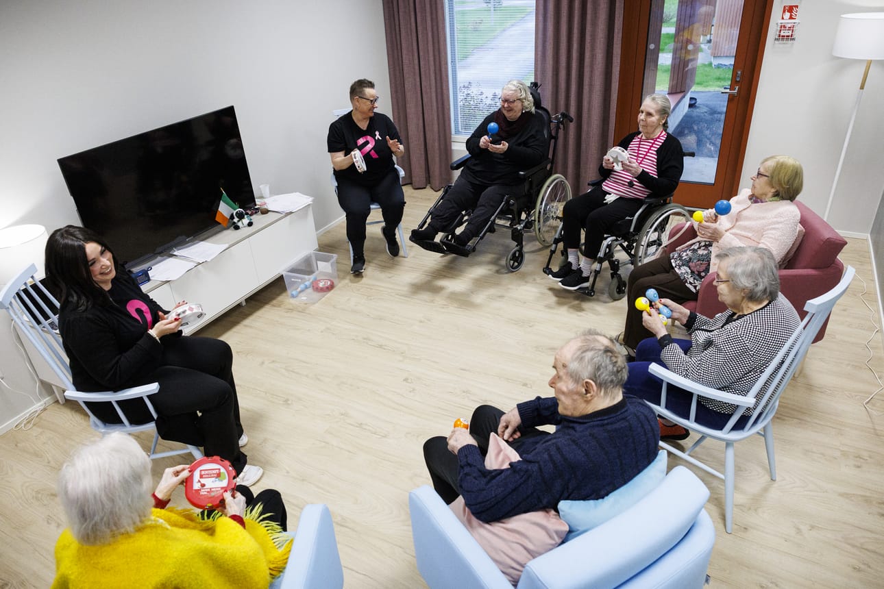 Sonas-tuokion osallistujat ovat löytäneet yhteisen rytmin. Rinnekodit Lumouksen yksikköjohtaja Kaisa Hyyryläinen (vas.) ja hoitaja Kati Rasmus erotuvat musta-pinkeissä paidoissaan.