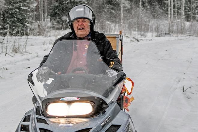 Antti Köykkä moottorikelkkansa kanssa on tuttu näky Lauhanvuoressa näinä aikoina. Vaikka ikää on mittarissa, Köykkä on terve mies, ja jaksaa edelleen painaa hommia. KUVA: JORMA HAVULA