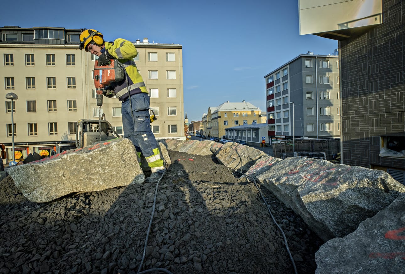 Juho Hiltula muotoilee iskuporakoneella kivikukon murikkaa passaamaan sille kuuluvalle paikalle oikeaan asentoon.