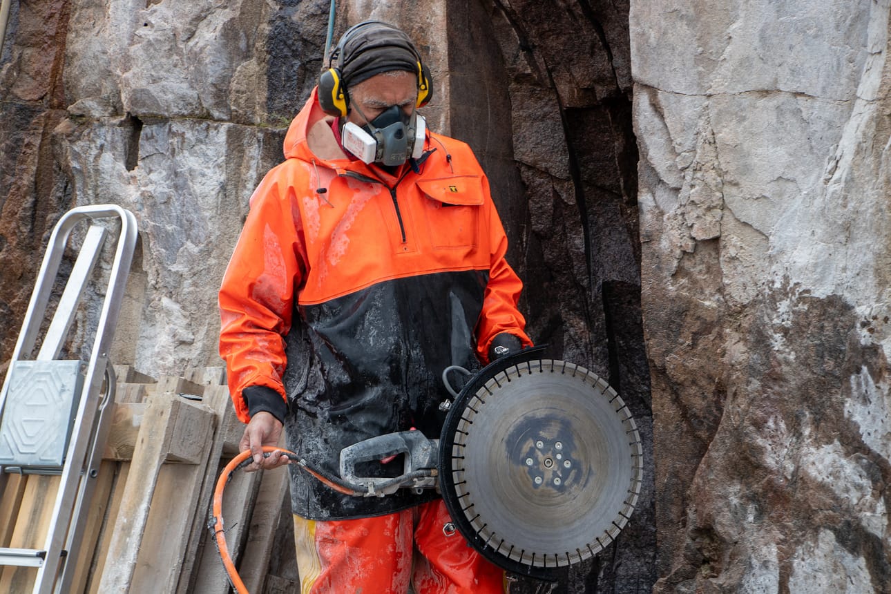 Hollantilais-brittiläinen kuvanveistäjä Chris Peterson tunnetaan suurikokoisista julkisista veistoksista. Peterson työstää Aurinkojärvellä Art Linnakallio -teostaan jykevillä työkaluilla.
