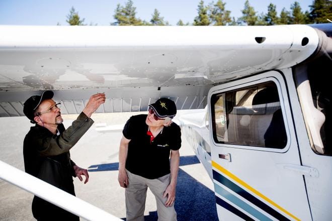 Laihialainen Matti Soininen (vas.) tarkastaa polttoaineen, eli ottaa ns. vesibensat Cessna 172 -koneesta Seinäjoen lentoasemalla perjantaina. Ilmajokelainen Niilo Ala-Könni seuraa tilannetta. Miehet olivat lähdössä palolennolle. KUVA: JAAKKO ELENIUS