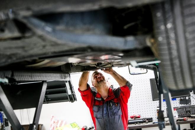 Autojen ilmastointikorjauksia tehdään nyt yli tuplasti enemmän kuin viime kesänä. Autohuolto Seitoyn mekaanikko Mikko Katila asentaa asiakkaan autoon uuden lauhdutinkennon. KUVA: JAAKKO ELENIUS