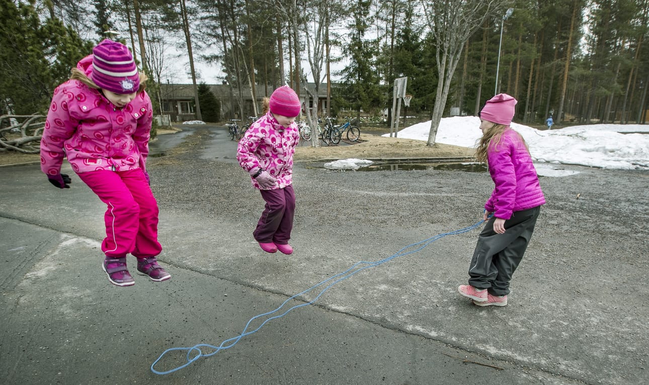 Iltapäiväkerholaiset Katri Orava (vas.), Janika Ukonmaanaho ja Anni Saarilampi leikkivät pihalla.