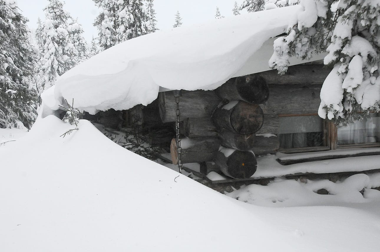 Arkistokuva lumesta mökin katolla.