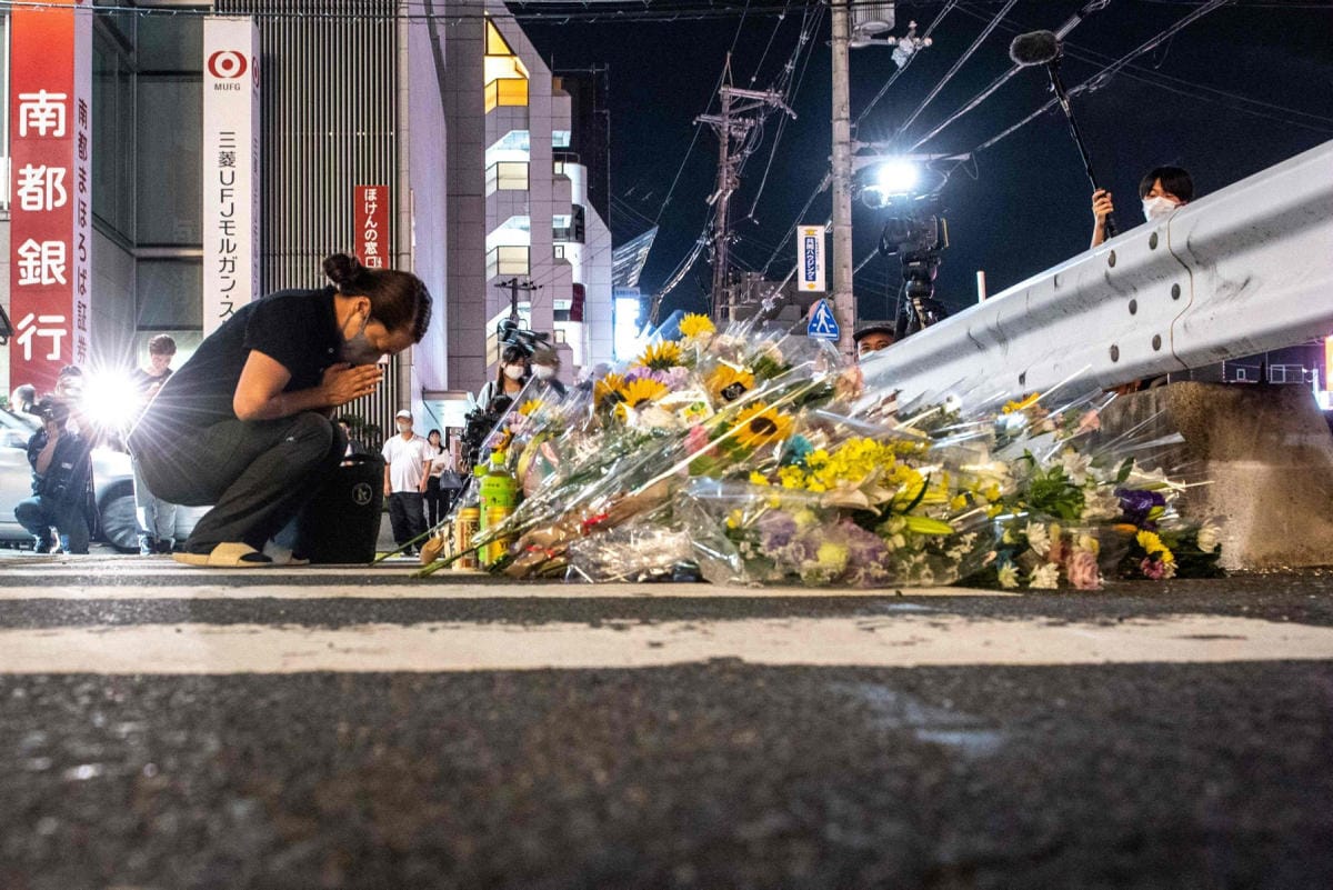 Sureva nainen polvistui Narassa paikalla, jossa Japanin entinen pääministeri Shinzo Abe ammuttiin. LEHTIKUVA/AFP