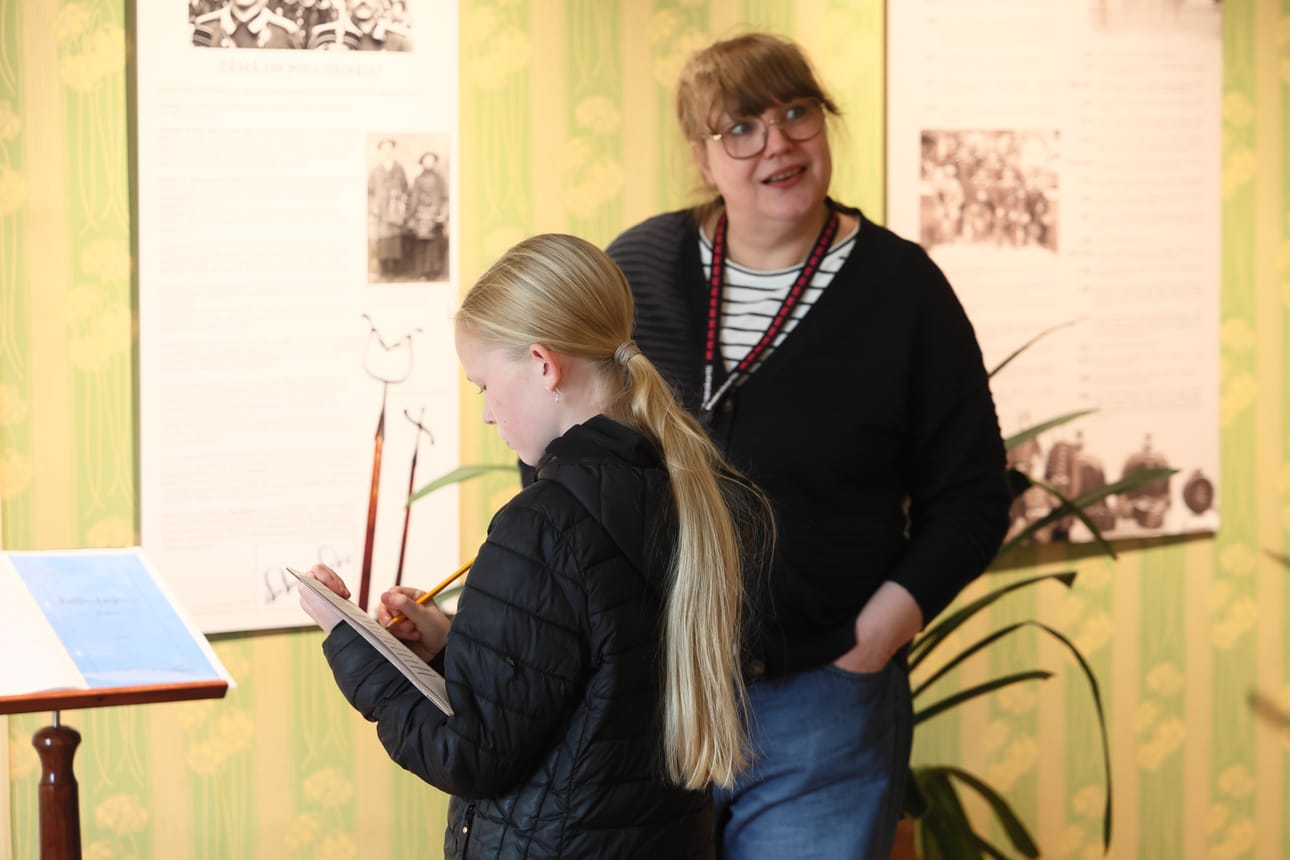 Näyttelyä kiertäessä sai halutessaan täyttää siihen liittyvän tehtävälapun. Venla Pyhäluotoa sen kanssa avittaa museo-opas Mirva Kangas.
