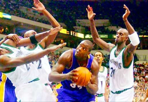 Voittojen takuumies . Shaquille O'Neal on Lakersin voittojen avain. Silloin kun peli kulkee, mies on mahdoton pideltävä. Tässä korin tekemistä estävät Minnesota Timberwolvesin Joe Smith ja Kevin Garnes sekä rikkoja Rod Strickland.