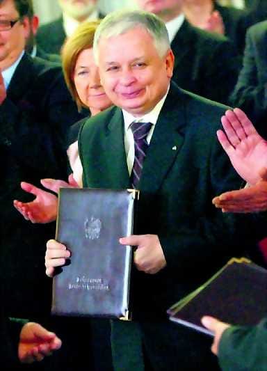 Vallan perään. Hymyilevä Lech Kaczynski esitteli maanantaina kansiota, jossa olivat viralliset tulokset presidentinvaaleista.