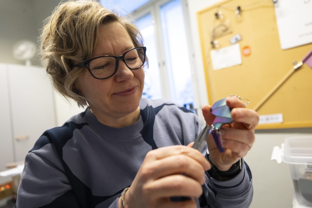 Graafinen suunnittelija Anne Kleemola valmistaa revontuliaiheisia korvakoruja Theodorin puistossa Tuirassa sijaitsevassa pajassaan.