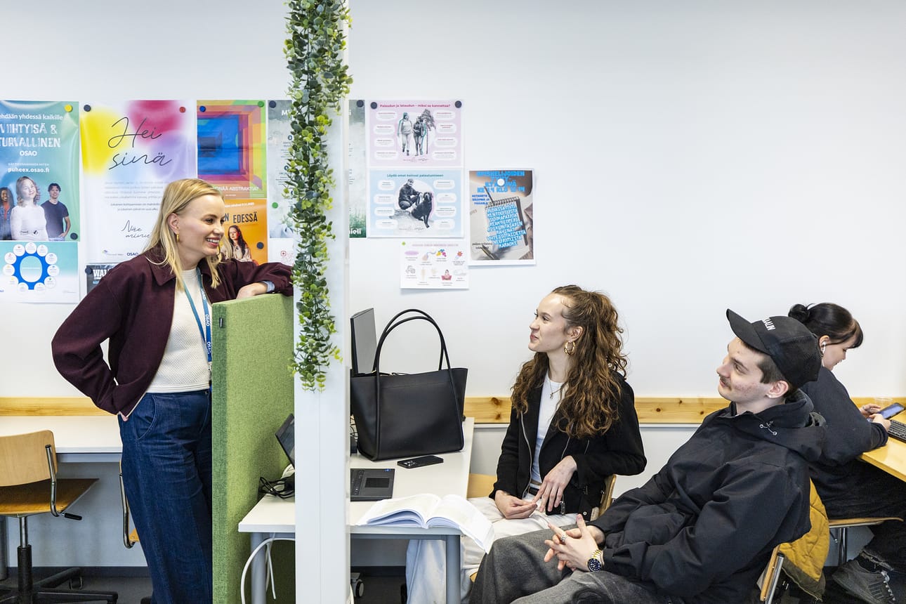 Opinto-ohjaaja Marianne Tapper (vas) keskustelee OSAOn opiskelijoiden Enni Asikaisen (kesk) ja Rasmus Kerkelän kanssa. Asikainen edistää näyttötehtäväänsä ja Kerkelä istuu seurana.