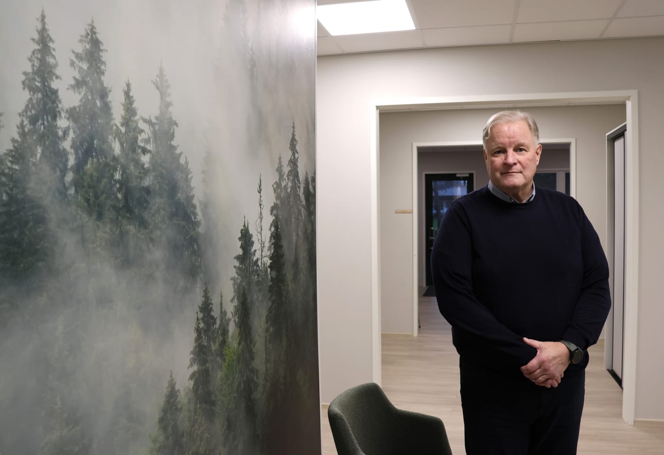 Toimitusjohtaja Timo Kuusisto Nordautomationin uudessa aulassa, jota hallitsee usvainen näkymä havumetsästä.