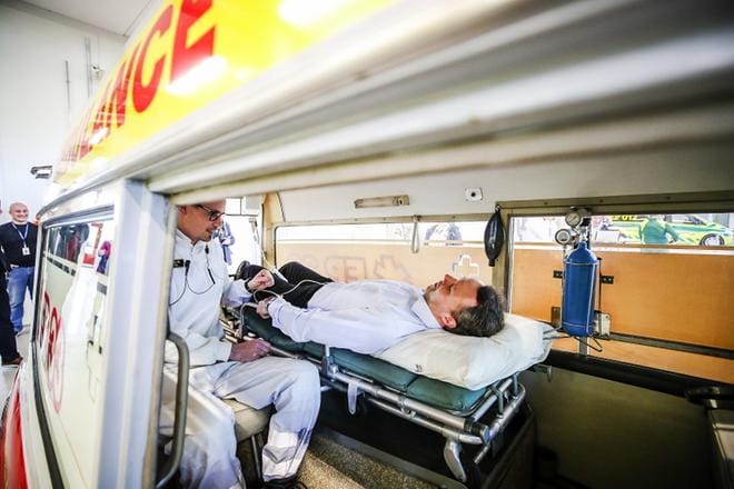 Lavastetussa kuvaustilanteessa kiinteistöpäällikkö Jimmy Liljeqvist saa apua ensihoitaja Miika Tölliltä ambulanssivanhuksen paarilla. KUVAT: KRISTA LUOMA
