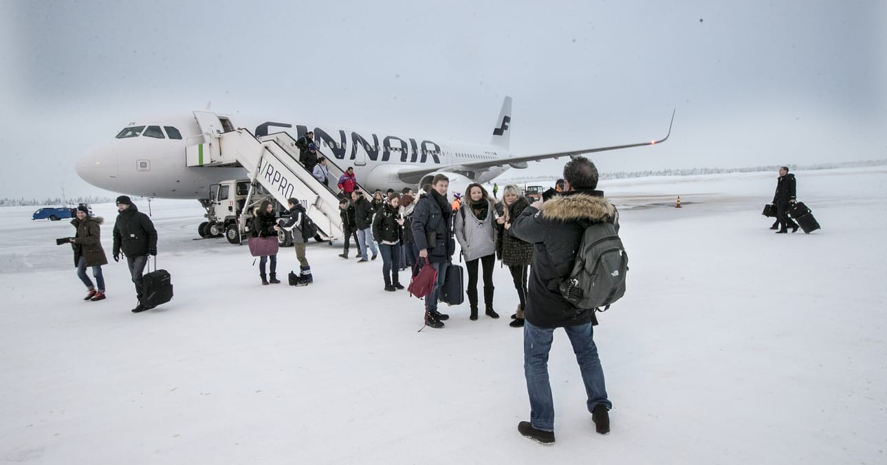 Pariisin-koneesta laskeutuneet matkailijat ottavat kuvia Kittilän lentoasemalla.