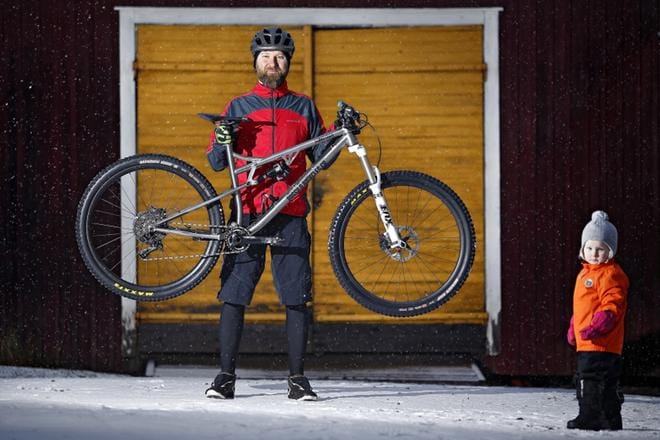 Markku Hautamäki on tyytyväinen suunnittelemaansa 29 tuumaiseen täysjousitettuun maastopyörään, joka painaa titaanirunkoineen alle 14 kiloa. Kaksivuotias Anna-tytär isänsä vierellä.KUVAT: TOMI KOSONEN