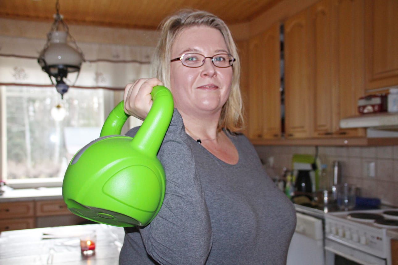 Kotona Anne-Mari Koski heiluttelee kahvakuulaa. Liikunnasta on tullut osa jokapäiväistä arkea.