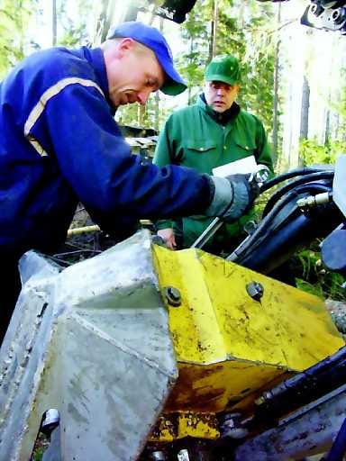 Metsäinsinööri Tapio Leskelä ja metsäkoneen kuljettaja Jarkko Leppälä tutkivat paatsaman lehtiä metsälain perusteella suojellulla alueella Reisjärven Pitkäjärvellä.