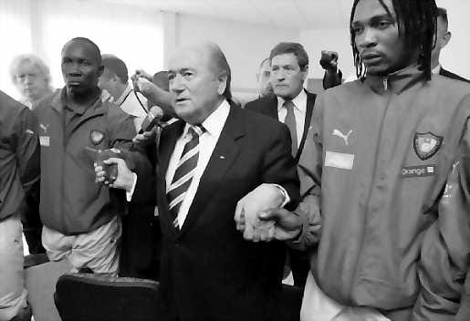 Hiljainen hetki. Kansainvälisen jalkapalloliiton puheenjohtaja Sepp Blatter kunnioittaa yhdessä kamerunilaispelaajien kanssa hetken hiljaisuudella torstaina menehtyneen Marc-Vivien Foen muistoa.